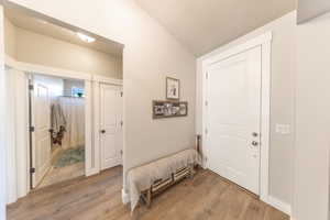 Entryway with light wood-type flooring and a textured ceiling