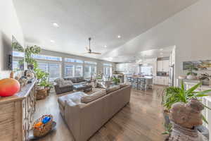 Living area with recessed lighting, a ceiling fan, vaulted ceiling, a textured ceiling, and hardwood / wood-style floors