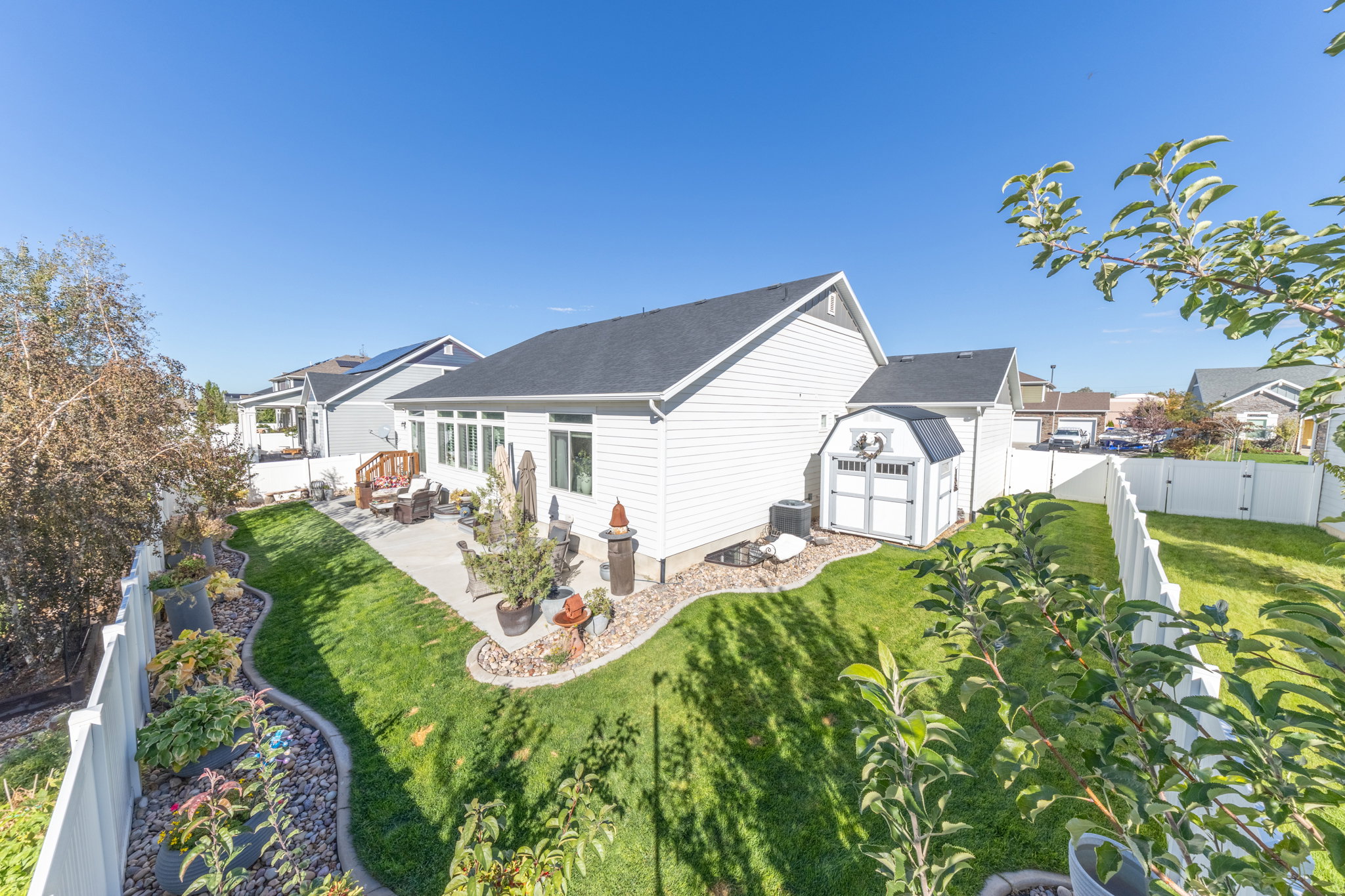 Rear view of house with a fenced backyard, a storage shed, and a patio area