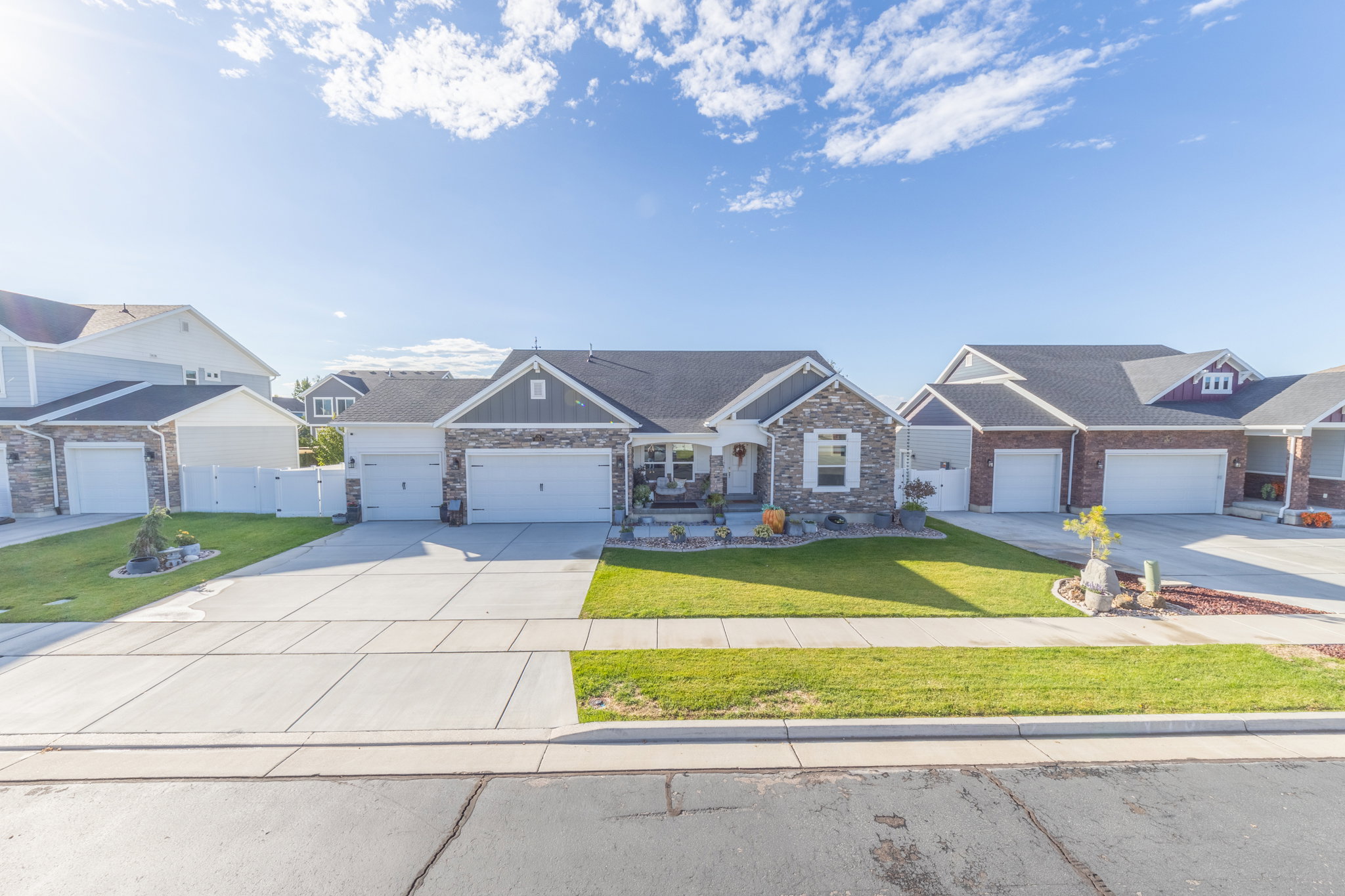 Craftsman-style house featuring driveway, stone siding, and an attached garage