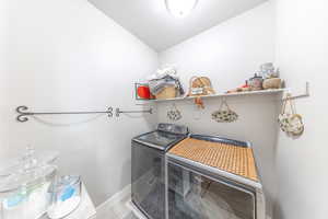 Laundry room featuring washing machine and clothes dryer and tile patterned flooring