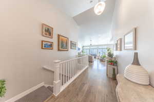 Corridor featuring an upstairs landing and wood-type flooring