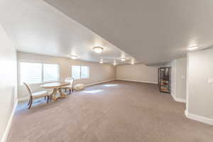 Unfurnished room featuring a textured ceiling and carpet floors