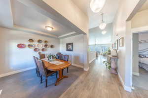 Dining area with wood finished floors and a raised ceiling