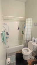 Bathroom with shower / bath combination with curtain and tile patterned flooring