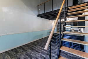 Staircase with wood finished floors and baseboards