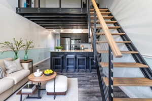Living area featuring stairway, dark wood finished floors, and beam ceiling