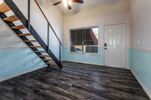 Foyer entrance featuring dark wood-style floors, stairs, and a ceiling fan