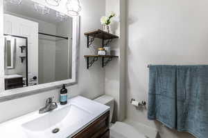 Full bath with vanity, a shower, and a textured wall