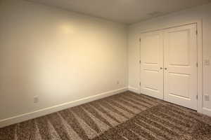 Bedroom  #3 featuring dark colored carpet and a closet