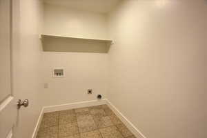 Washroom featuring electric dryer hookup, hookup for a washing machine, and light tile patterned floors