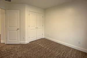 Bedroom #2 with dark carpet and a closet