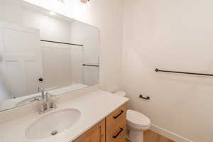 Full bath featuring vanity, a shower, and light wood-style flooring