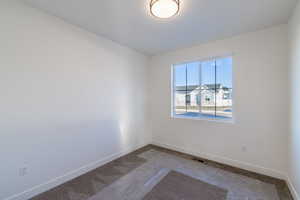 Carpeted empty room featuring baseboards