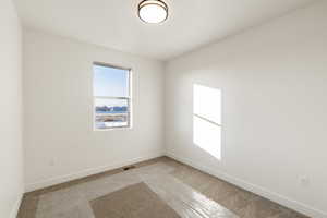 Carpeted spare room with baseboards