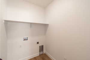 Laundry area with wood finished floors, washer hookup, and electric dryer hookup