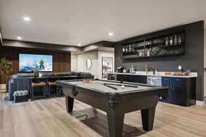 Rec room featuring bar with sink, light wood-style flooring, billiards table, and recessed lighting