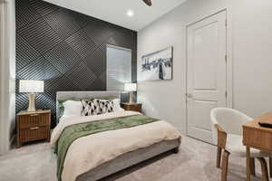Bedroom featuring an accent wall, carpet floors, a ceiling fan, and recessed lighting
