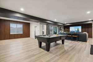 Recreation room with wooden walls, billiards table, light wood-style flooring, and recessed lighting