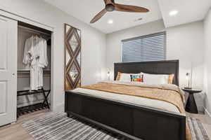 Bedroom with light wood-type flooring, a ceiling fan, recessed lighting, and a closet