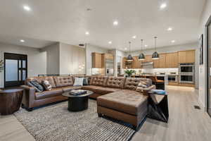 Living area with recessed lighting and light wood-style floors