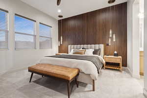 Carpeted bedroom featuring wood walls, an accent wall, a ceiling fan, and recessed lighting