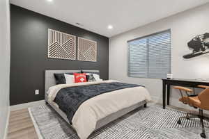 Bedroom featuring wood finished floors, recessed lighting, and an office area