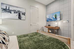 Bedroom featuring tile walls