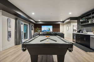 Rec room with pool table, light wood-style floors, recessed lighting, bar with sink, and wine cooler