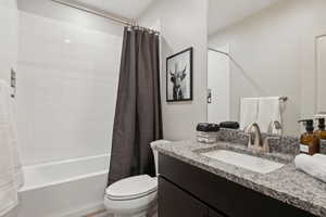 Bathroom featuring vanity and shower / bath combination with curtain