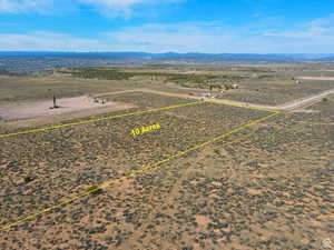Aerial view of sparsely populated area with property parcel outlined and a mountain backdrop