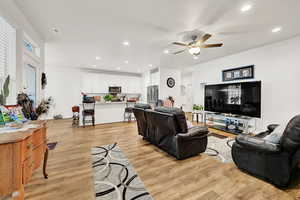 Living room featuring recessed lighting, light wood-style floors, and a ceiling fan