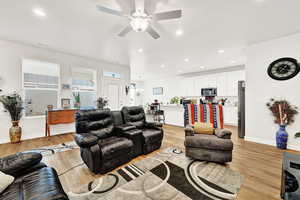 Living room featuring recessed lighting, light wood-style flooring, a ceiling fan, and a chandelier