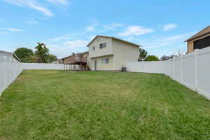 Fenced backyard with stairway and a wooden deck