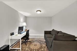 Home office with light colored carpet and baseboards