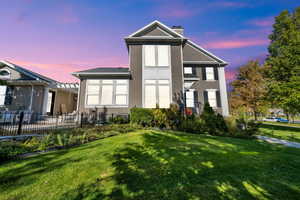 Back of house at dusk with stucco siding and a chimney