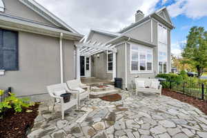 View of patio / terrace with an outdoor fire pit and a pergola