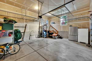 Garage with freestanding refrigerator and a garage door opener