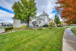 View of front facade with a chimney, a front lawn, a patio area, and stucco siding