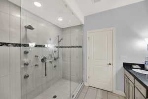 Full bathroom featuring vanity, light tile patterned flooring, a shower stall, and recessed lighting