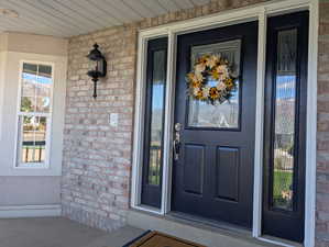 Doorway to property featuring brick siding