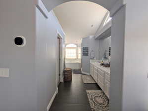 Full bathroom with a tub to relax in, vanity, and dark tile patterned floors
