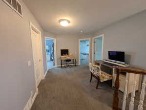 Office area featuring a textured ceiling and dark carpet