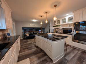 Kitchen with backsplash, a kitchen breakfast bar, pendant lighting, appliances with stainless steel finishes, and recessed lighting
