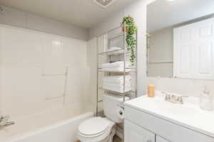 Bathroom featuring vanity, a textured ceiling, and shower / bathtub combination
