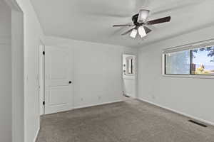 Primary bedroom with carpet, ensuite bath, and a ceiling fan