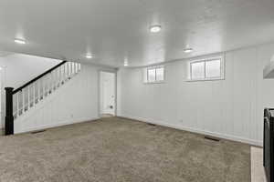 Family room with carpet flooring and wood walls