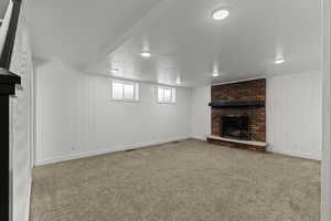 Family room featuring a brick fireplace, carpet,  and wooden walls