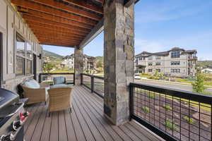 Wooden deck featuring a grill and a residential view