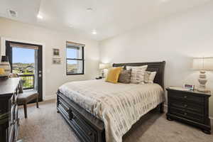 Bedroom featuring light colored carpet, access to exterior, and recessed lighting